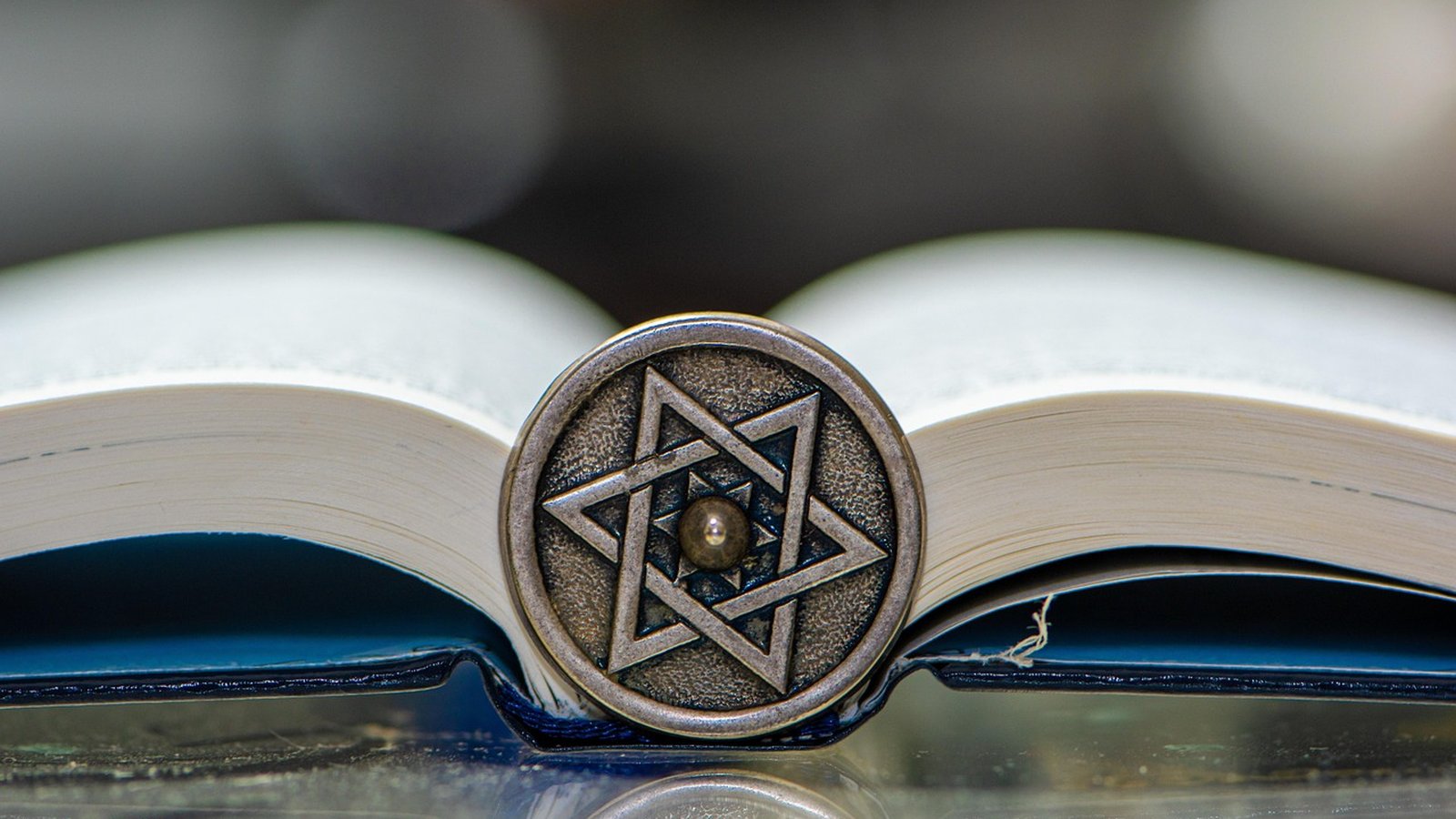 מדליון מגן דוד מונח על ספר פתוח